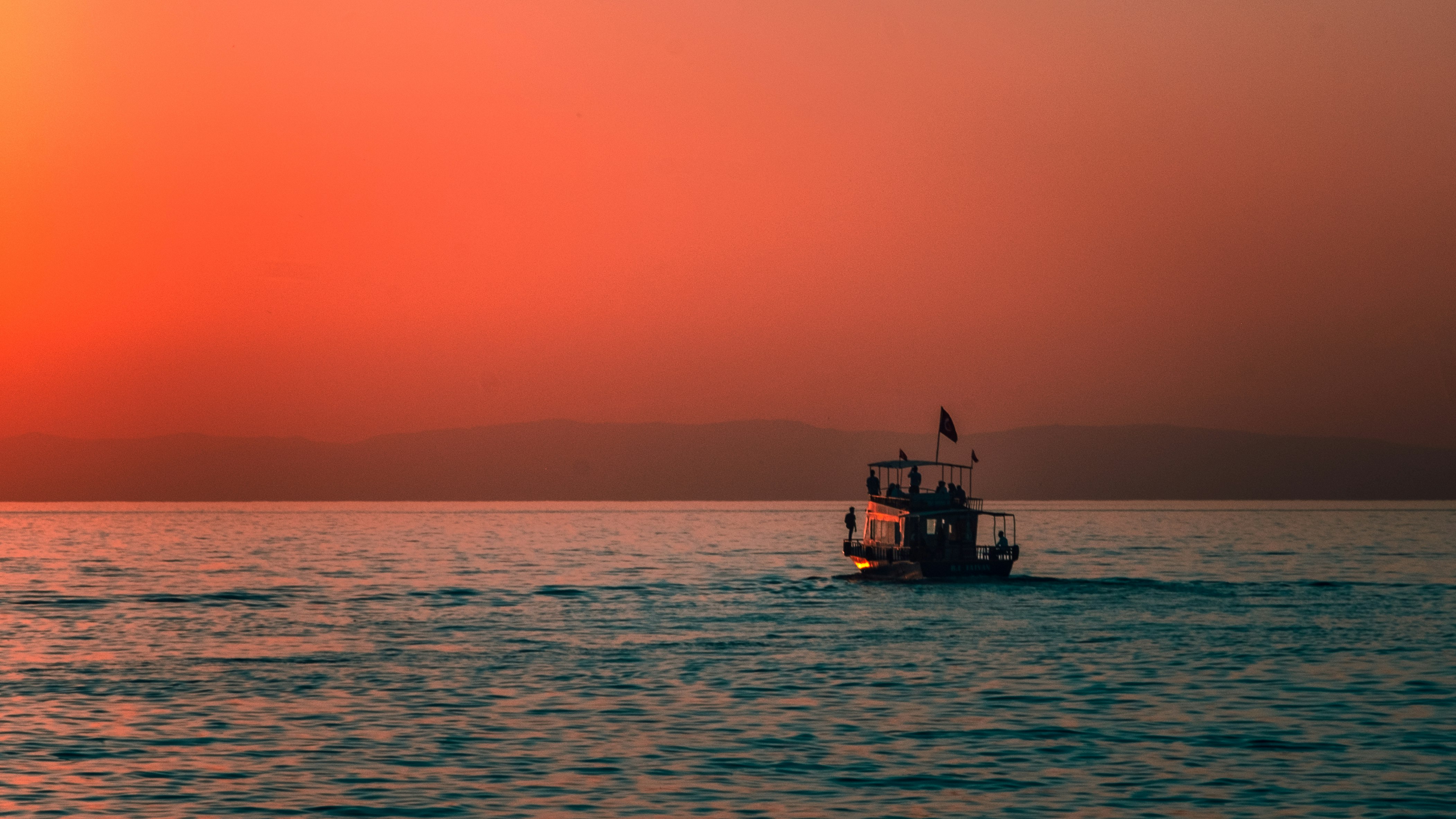 silhouette of boat on sea during sunset